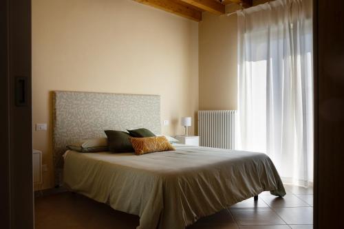 a bedroom with a bed and a large window at Casa con ampio terrazzo, vista lago e giardino in Toscolano Maderno