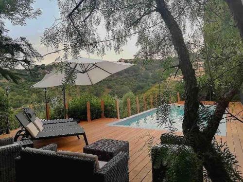 une terrasse avec une table, un parasol et une piscine dans l'établissement Côte d’azur: Charmante villa, vue mer, piscine,clim,calme 8/10 personnes, à Roquebrune-sur Argens