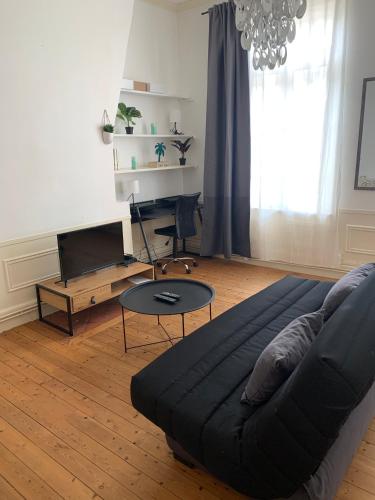 een woonkamer met een bank en een tafel bij Le Voltaire 4 chez Adrien Hyper centre in Saint-Quentin