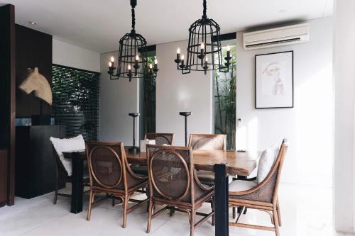 una sala da pranzo con tavolo e sedie in legno di Villa Ambergris by Nakula a Nusa Dua