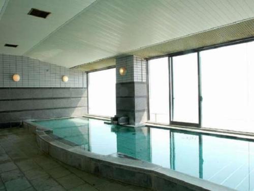 an empty swimming pool with blue water in a building at Hotel Cetus Royal in Higashiizu