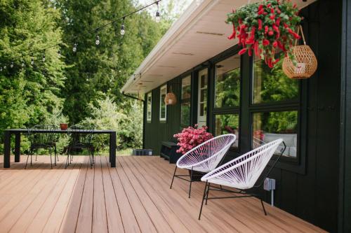 a deck with two chairs and a table with flowers at Bay Point Hideaway in the Woods in Beulah