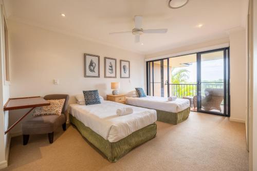 a bedroom with two beds and a balcony at Cavvanbah Beach Villa in Byron Bay