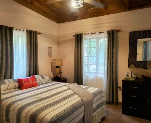 sypialnia z łóżkiem i oknem w obiekcie Ecoscape Jamaica - Cottages by the river w mieście Ocho Rios