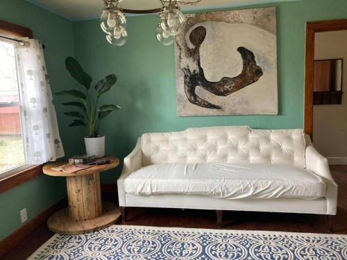 uma sala de estar com um sofá branco e uma mesa em Green Home 25 min from downtown em Nashville