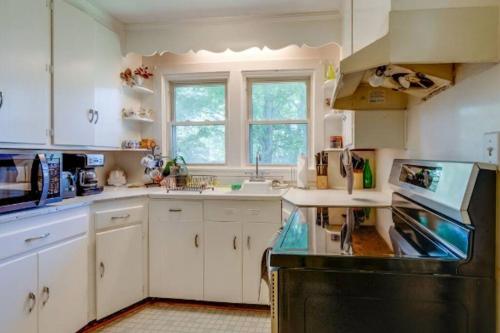 a kitchen with white cabinets and a black appliance at Green Home 25 min from downtown in Nashville