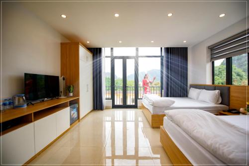 een slaapkamer met 2 bedden, een tv en een balkon bij Ninh binh Green Diamond Homestay in Ninh Binh