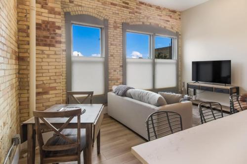 a living room with a couch and a tv at Golden Lofts Unit 2 Downtown Traverse City 1bd 1ba in Traverse City