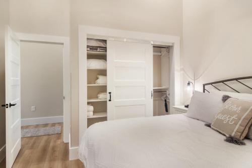 a white bedroom with a bed and a closet at Golden Lofts Unit 2 Downtown Traverse City 1bd 1ba in Traverse City