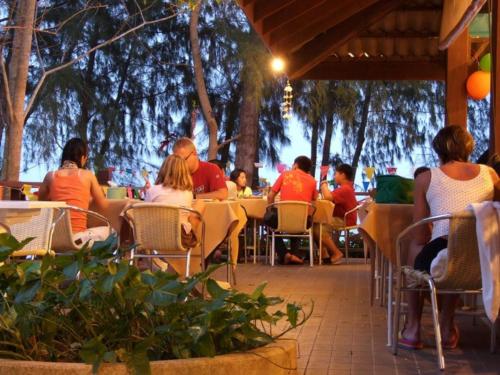 a group of people sitting at an outdoor restaurant at Bayview Beach Resort in Ban Krut