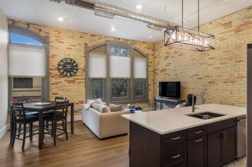 a kitchen and living room with a brick wall at Golden Lofts Unit 4 Downtown Traverse City 2BD 2BA in Traverse City