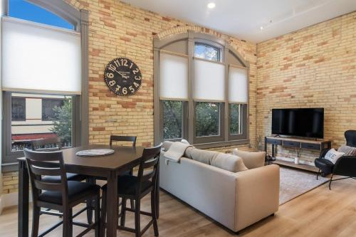 a living room with a clock on a brick wall at Golden Lofts Unit 4 Downtown Traverse City 2BD 2BA in Traverse City