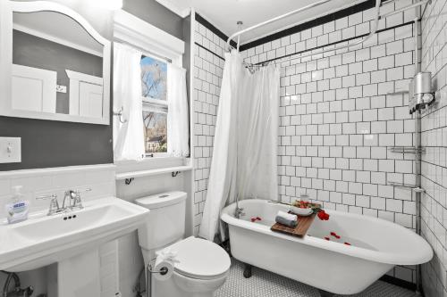 a bathroom with a toilet and a sink and a tub at The Wildflower Vacation Cottage in Colorado Springs