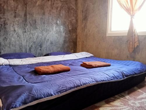 Una cama con dos almohadas marrones encima. en Lanta Farita House, en Phra Ae beach