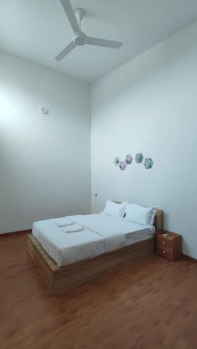 Gopeng Serumah Holiday House في Gopeng: غرفة نوم بيضاء مع سرير وسقف