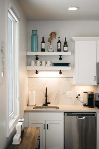 a kitchen with white cabinets and a sink and a window at Cypress Parkside Condo in Traverse City