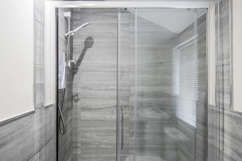 a shower with a glass door in a bathroom at 2-Bed Studio in Bedford-Hospital-VictoriaD in Bedford