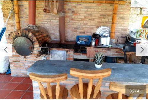 eine Küche mit einem Tisch und 2 Holzhockern in der Unterkunft Finca las palmeras /Cabaña de Ian in San Antonio del Tequendama