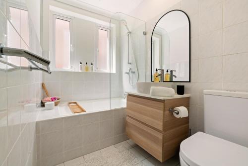 bagno con lavandino, servizi igienici e specchio di Beach-side North Bondi a Sydney