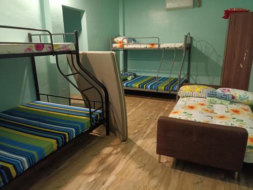 a room with two bunk beds and a chair at Azulea Lodging House Oslob in Oslob