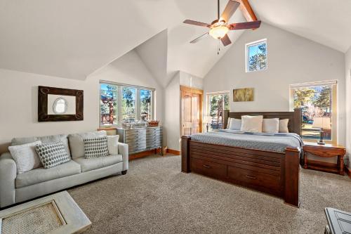 a bedroom with a bed and a couch and windows at Black Bear Cabin with Hot Tub in Woodland Park
