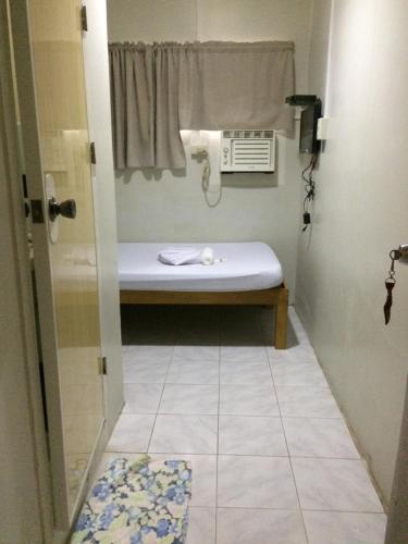 ein kleines Bad mit einem Waschbecken und einem Fenster in der Unterkunft CrisFil's Lodge Incorporated in Dumaguete