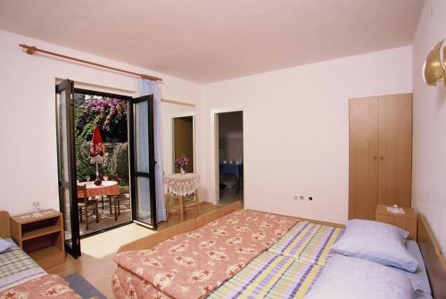 a bedroom with a bed and a balcony with a table at Apartments Boljat in Supetar