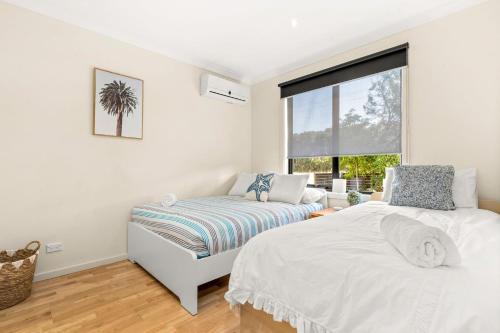 a bedroom with two beds and a window at Back Beach Beauty in Smiths Beach