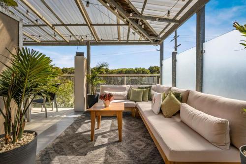 a living room with a couch and a table at Back Beach Beauty in Smiths Beach