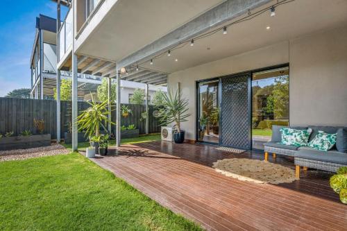 a patio of a home with a couch and grass at Back Beach Beauty in Smiths Beach