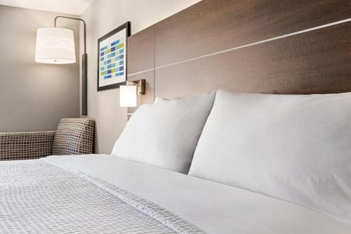 a hotel room with a bed with white pillows at Holiday Inn Express Hotel & Suites Anniston/Oxford by IHG in Oxford