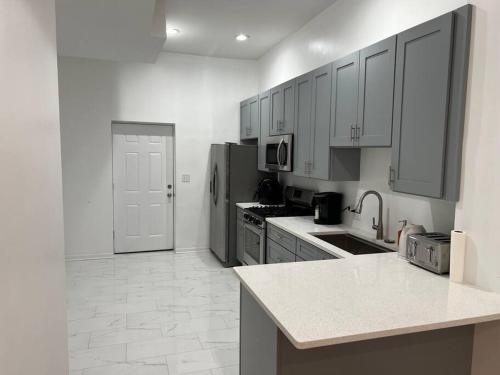 シカゴにあるAdorable 2 bedroom with free street parkingのキッチン(白いキャビネット、白いカウンタートップ付)