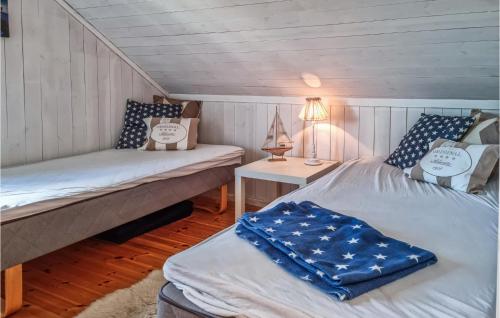 um quarto com duas camas e uma mesa com um candeeiro em Gorgeous Home In Risr With House A Panoramic View em Risør