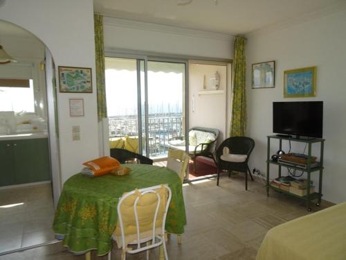 un salon avec une table et un tissu de table vert dans l'établissement Studio à Hyères Port avec loggia et parking - FR-1-335-187, à Hyères