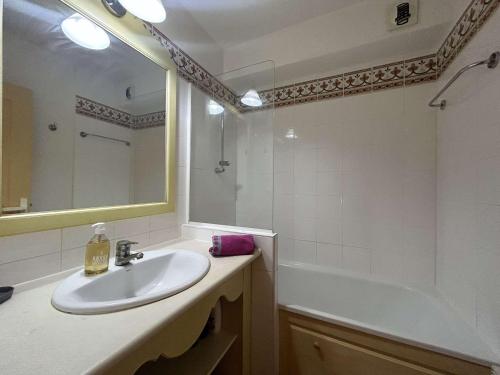 une salle de bain avec un lavabo, une baignoire et un miroir dans l'établissement Studio cabine 4 pers. avec piscine commune et parking - FR-1-226-510, à Roquebrune-sur Argens