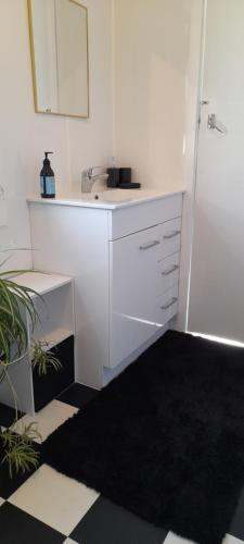 een witte badkamer met een wastafel en een spiegel bij Ellie's Villa in Brydone
