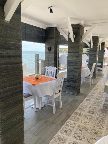 a dining room with a table and chairs and the ocean at Villa Agung Beach Inn in Lovina