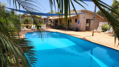 a large blue swimming pool in front of a house at Samson Beach Chalets in Point Samson