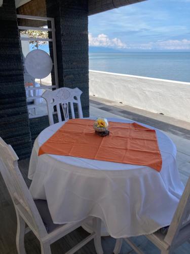 a table and chairs on a patio with the beach at Villa Agung Beach Inn in Lovina