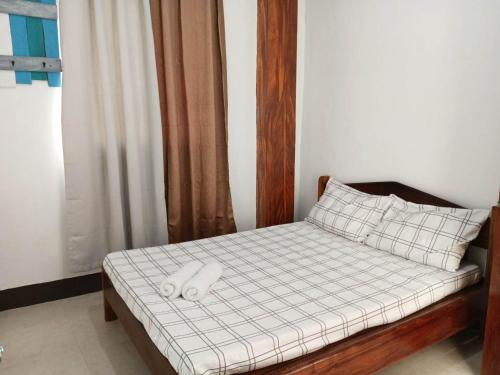 Una cama con dos almohadas blancas encima. en DGA Pension House, en Corón