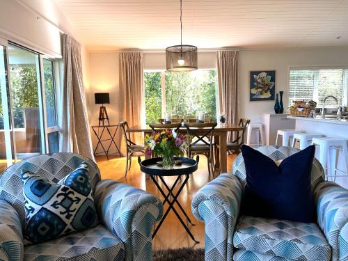 a living room with two couches and a table at Treghan Luxury Lodge in Kerikeri
