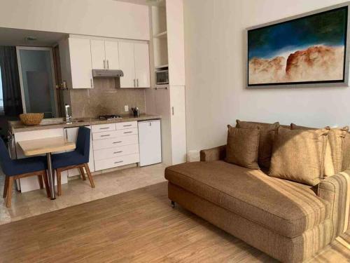 ein Wohnzimmer mit einem Sofa und einer Küche in der Unterkunft Lujoso Loft moderno Santa Fe vive en la naturaleza in Mexiko-Stadt