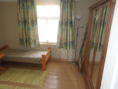 mały pokój z łóżkiem i oknem w obiekcie Holiday Home on Liepajas Street w mieście Aizpute