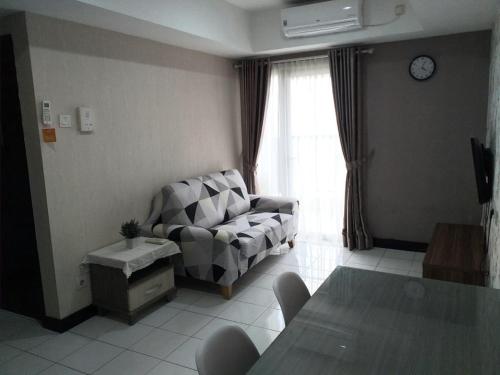 - un salon avec un canapé et une fenêtre dans l'établissement The Wave Apartment, à Jakarta