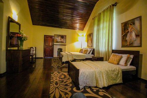um quarto de hotel com duas camas e um quarto com em Brockenhurst Bungalow em Nuwara Eliya
