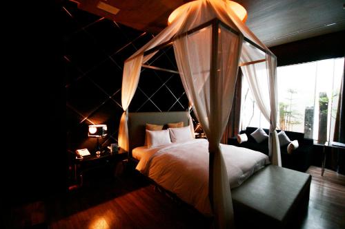 um quarto com uma cama de dossel e uma janela em The Yorker Deluxe Motel em Taoyuan