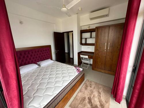 可倫坡的住宿－Fully Furnished Apartment，一间卧室配有一张带红色窗帘的大床