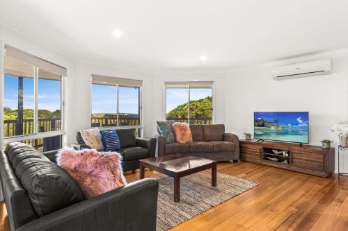 a living room with a couch and a tv at Seas the day in Kilcunda