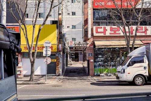 a white van parked on a city street with buildings at Life in Euljiro in Seoul