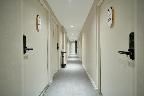 a long hallway with white walls and a long corridor at Life in Euljiro in Seoul